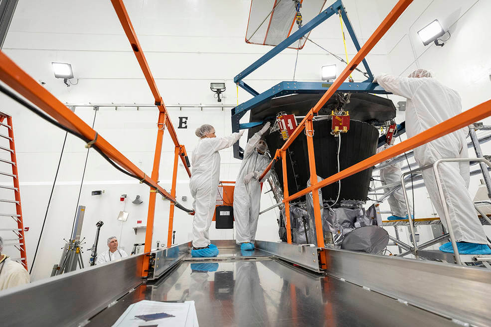 Parker Solar Probe’s heat shield, called the Thermal Protection System, is lifted and realigned with the spacecraft’s truss as engineers from the Johns Hopkins Applied Physics Lab prepare to install the eight-foot-diameter heat shield on June 27, 2018.